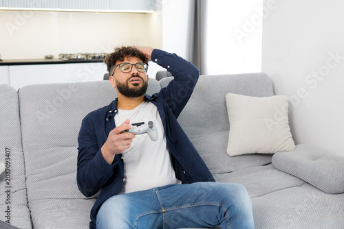 Man feeling frustrated and disappointed playing video game