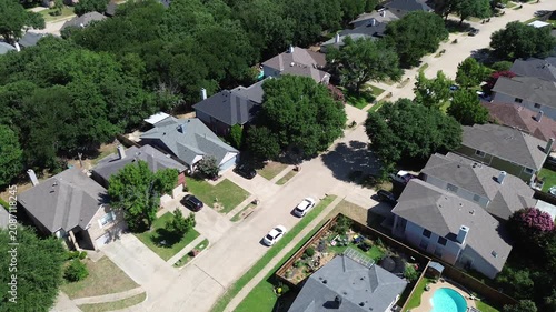 Fenced residential lots feature private yards with sparkling blue pools. Sharp roof pitches meet dense perimeter woodland, capturing desirable suburban lifestyle features in Flower Mound, Texas