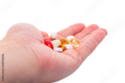 Hand holding assorted medicines and supplements isolated on white background
