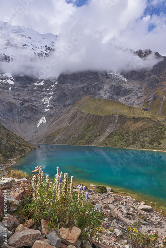 Turquoise Humantay lake under snowcapped mountain and clouds in Andes Peru