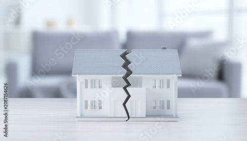 Real estate problems represented by a small house model undergoing property separation. Home, division, property, separation
