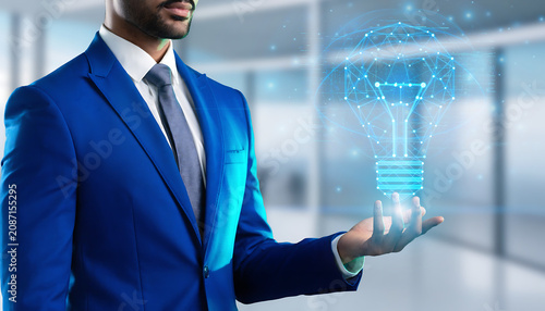 Innovative work concept showing a hand interacting with a holographic lightbulb and network connections. Conectivity concept
