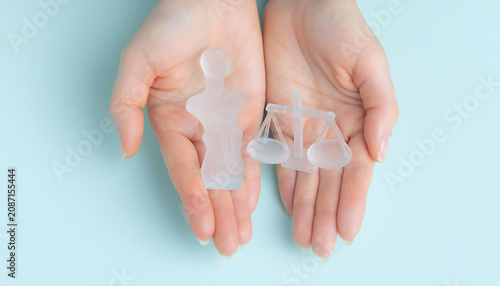 Concept of corporate compliance and business ethics shown by a hand holding a frosted glass scale figure.
Compliance 