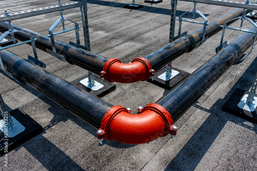 Canvas Print Photo of two parallel HVAC, two pipe, heating and cooling black metal pipes with