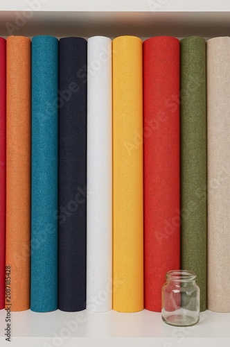 Colorful Rolls of Fabric Arranged on a Shelf in a Craft Room During Daytime