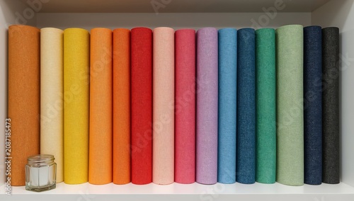 Colorful Rolls of Fabric Arranged on a Shelf in a Craft Room During Daytime