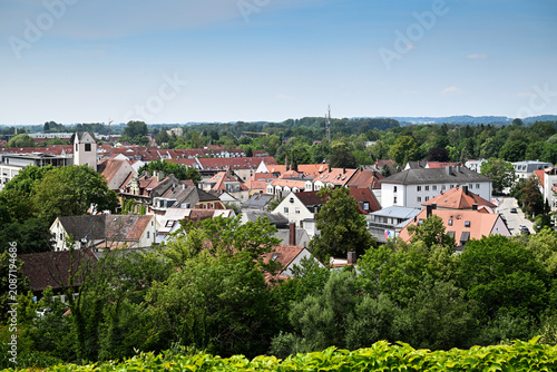 Panoramic small town rooftops with trees and church tower