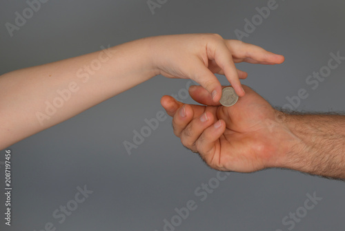 Konstfotografi Parent and child hands exchanging coin for family finance, allowance and savings education concept