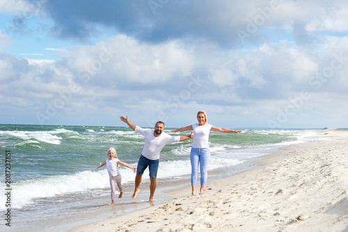 Foto A little girl and her parents walk on the beach on the Baltic Sea in Lithuania