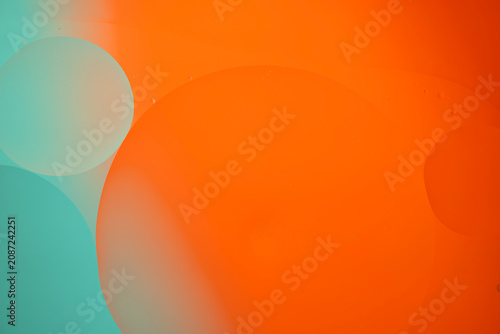 Oil and water bubbles abstract teal orange background