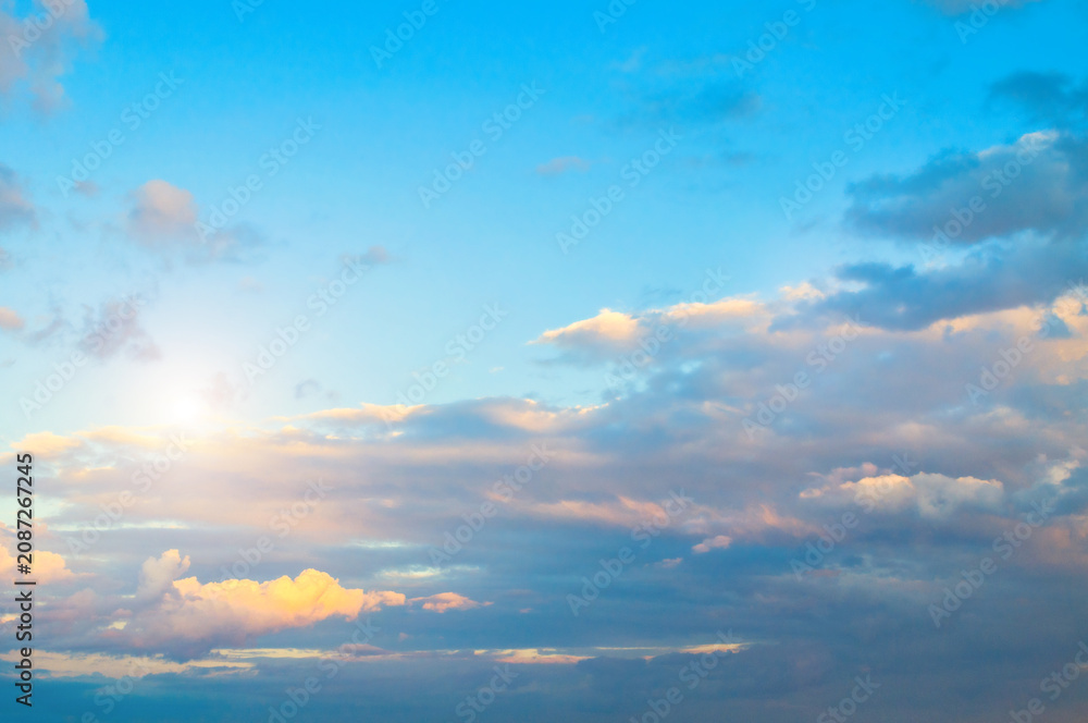 Obraz premium Blue sky background - sunset colorful clouds lit by sunlight