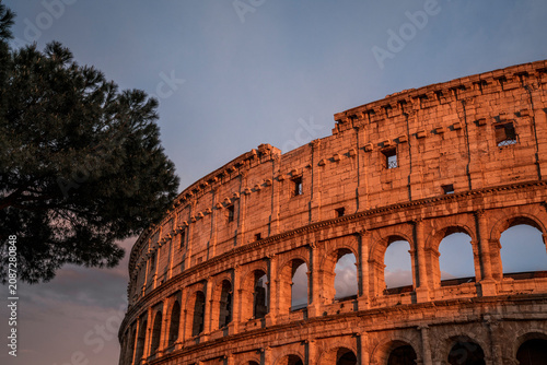 Fotografía Colosseum in Rome at sunset, warm evening light on ancient stone arches with sil