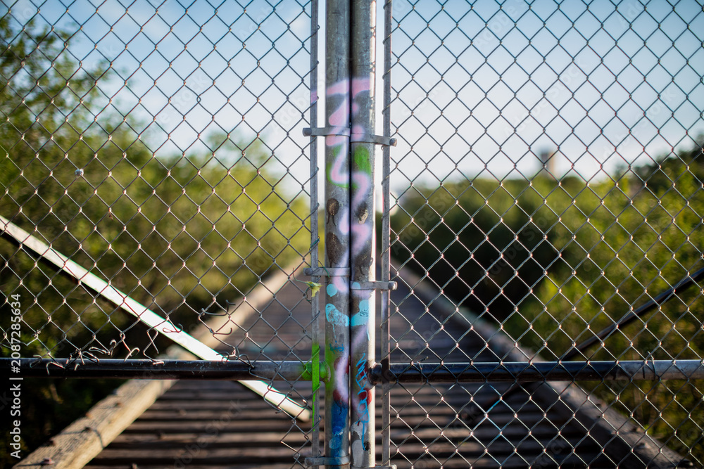 Fototapeta premium chain link fence with graffiti