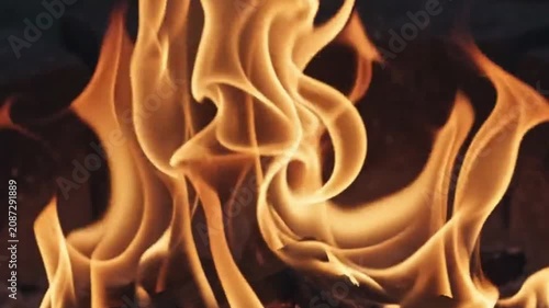 Closeup of bright orange flames from a wood fire burning in a fireplace