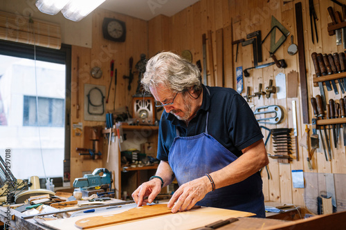 Man crafting guitar in workshop with passion and skill