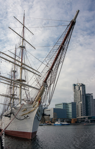 Canvas Print Sailing ship, bowsprit, high-rise city buildings in background