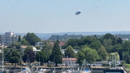 Friedrichshafen, Germany - June 27, 2026: A Zeppelin airship flying over the city and Lake Constance. Friedrichshafen is closely associated with Zeppelin airships and aviation history.