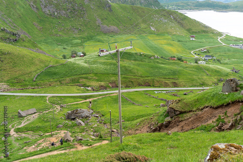 Power lines crossing green countryside landscape in remote rural area