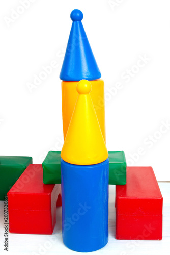 A colorful rocket built from plastic toy blocks standing on a white surface.