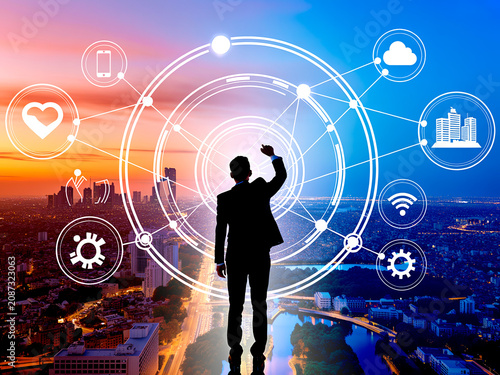 Professional Businessman Interacting with Futuristic Digital Network Interface Over a Vibrant Urban Cityscape at Sunset for Advanced Global Connectivity Concepts