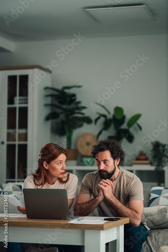 Fotografie Couple budgeting managing finances at home, facing financial stress and debt, pl