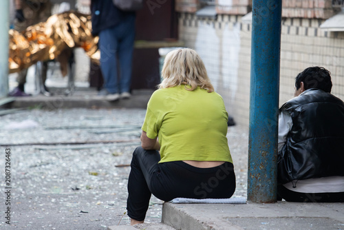Canvastavla Despondent people sitting amidst debris after a devastating urban disaster