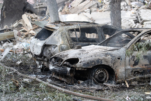 Photography Charred and completely incinerated cars buried in debris after a catastrophic ex