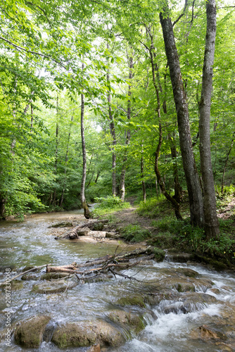 summer period - granite canyon of a mountain river, walking along a stone riverbed, rapid flow of water, close-up