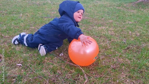Cute toddler playing with an orange balloon