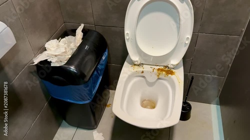 The toilet is made of white porcelain with an open lid and discolored water visible, stained with yellow feces. Dirty public toilet