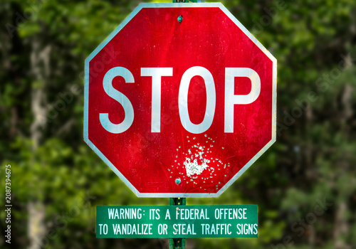Foto Vandalized stop sign with federal warning