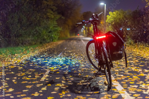 Foto Bicycle parked on autumn road at night.
