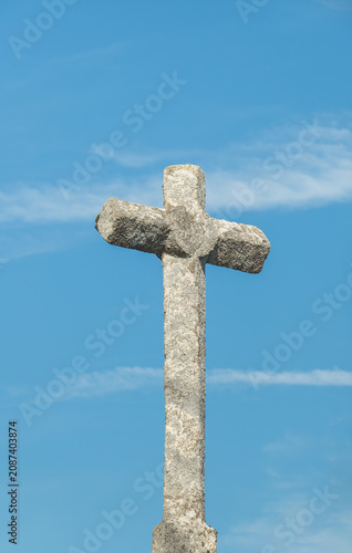 Old stone cross against a blue sky