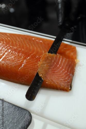 Obraz na płótnie experto cortando loncha de salmón ahumado fresco con cuchillo de corte fino