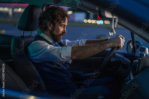 Vászonkép Man driving car at night concentrating on road