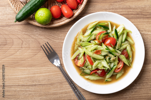 Spicy cucumber salad on wooden background, Local Thai food, Table top view