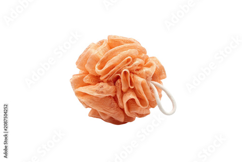 A single peach colored mesh bath sponge with a white elastic loop isolated on a solid black background, soft texture for body scrubbing