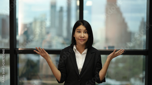 Fotografía Asian Businesswoman Shrugging with Frustrated Expression in Modern Office Settin
