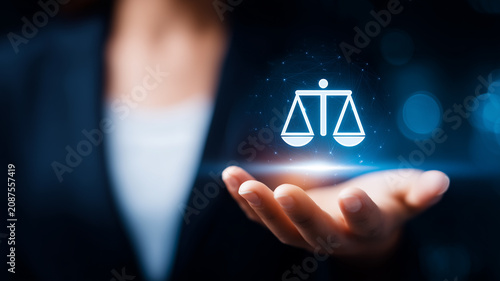 Justice scales in a business hand representing legal guidance, compliance, ethical decision making, and professional law services.
