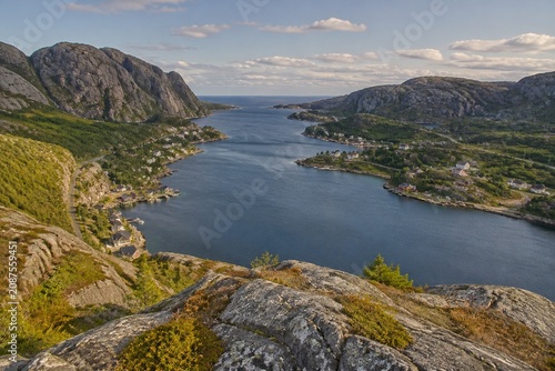Cliffside view of a long sea inlet with small villages along the shore.