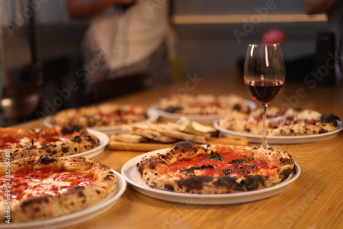 Bild auf Leinwand Fresh Neapolitan Pizzas and Red Wine on a Wooden Table