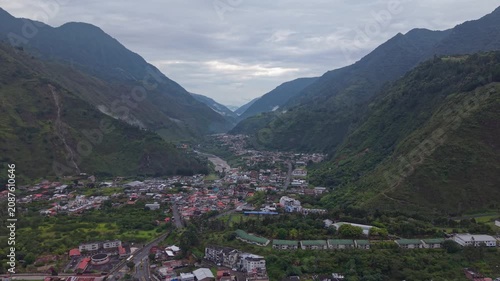 Aerial view of Banos town nestled in a lush green valley surrounded by mountains