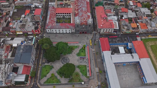 Aerial view rising above central plaza and historic church in Banos, Ecuador cityscape
