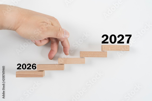 Finger Walking Up Wooden Steps From 2026 to 2027 New Year Business Growth Concept