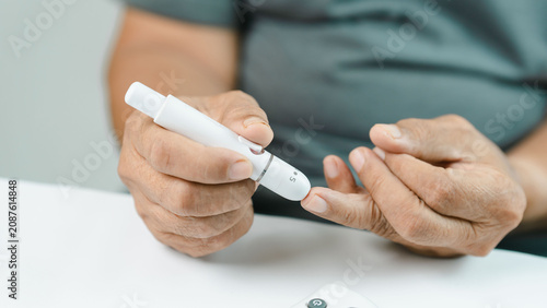 Cuadro en lienzo Close-up of a senior adult using a blood glucose meter for diabetes monitoring at home