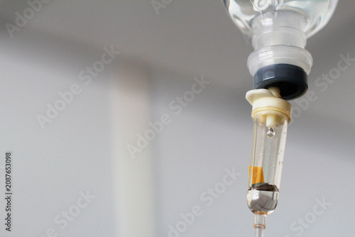 Cuadro en lienzo Macro shot of a saline droplet falling inside an intravenous drip chamber with copy space