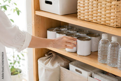 防災備蓄品を棚に並べ整理する手元 災害に備える収納棚