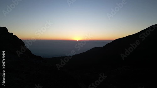 Drone footage capturing a sunrise moment at Mount Papandayan, West Java, Indonesia. Clear cloudless sky with a blue-to-orange gradient stretching across the horizon.