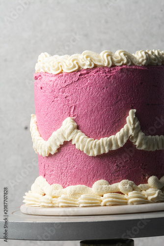 pink and cream vintage style cake on a dessert stand, trending hot pink vintage buttercream cake on a white background, process of decorating a buttercream cake