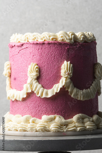pink and cream vintage style cake on a dessert stand, trending hot pink vintage buttercream cake on a white background, process of decorating a buttercream cake